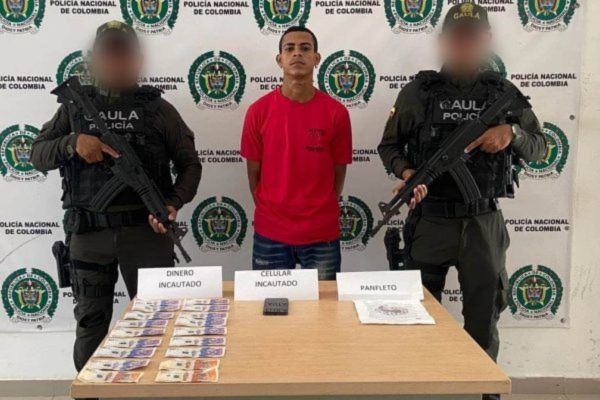 Andrés Felipe Sánchez, presunto integrante del Clan del Golfo capturado en Riohacha, junto con el material incautado durante el operativo.