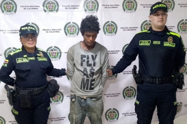Andrés Felipe Olarte Sierra, presunto homicida de una persona en Cali, Valle del Cauca en compañía de miembros de la Policía Nacional. Foto Fiscalía