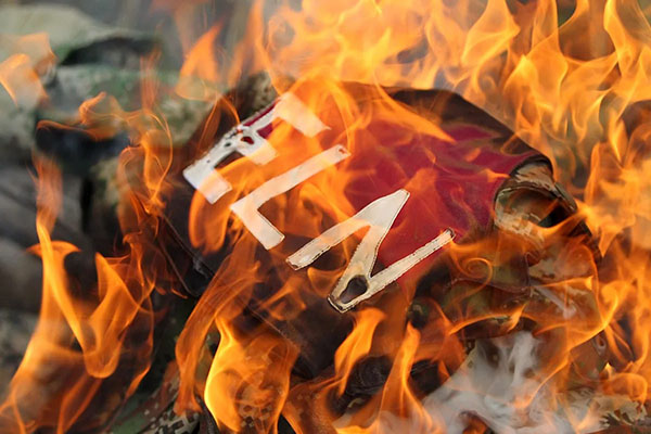 Detalle de un uniforme del grupo armado ilegal Ejército de Liberación Nacional al ser incinerado por autoridades indígenas, en el municipio de Corinto. EFE/Ernesto Guzman Jr.
