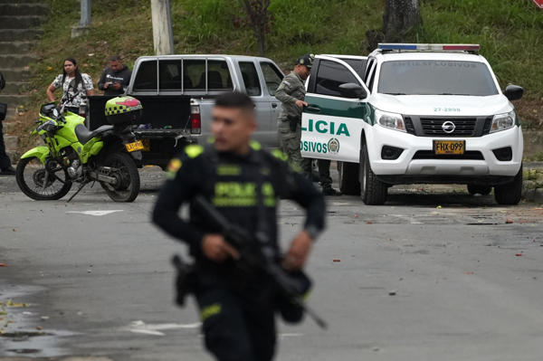 Policías inspeccionan el lugar donde un artefacto explosivo acabó con la vida de dos policías este martes, en Cali (Colombia). Dos agentes fallecieron tras la detonación de un explosivo cuando se desplazaban por una avenida de la capital del Valle del Cauca, informaron fuentes oficiales. EFE/ Ernesto Guzmán