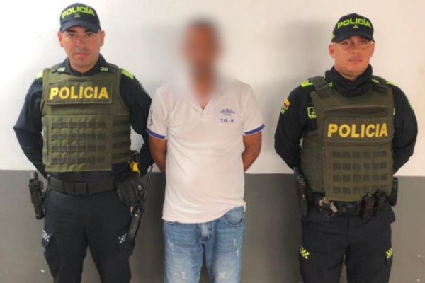 Entre los dos uniformados de la Policía Nacional aparece el procesado por intento de homicidio. Foto Fiscalía 