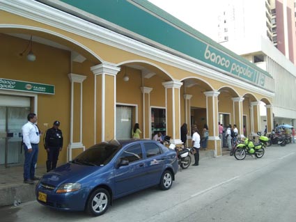 El coronel de la Policía cuando llegaba a conocer del caso y al lado, la Gerenta de la entidad bancaria.