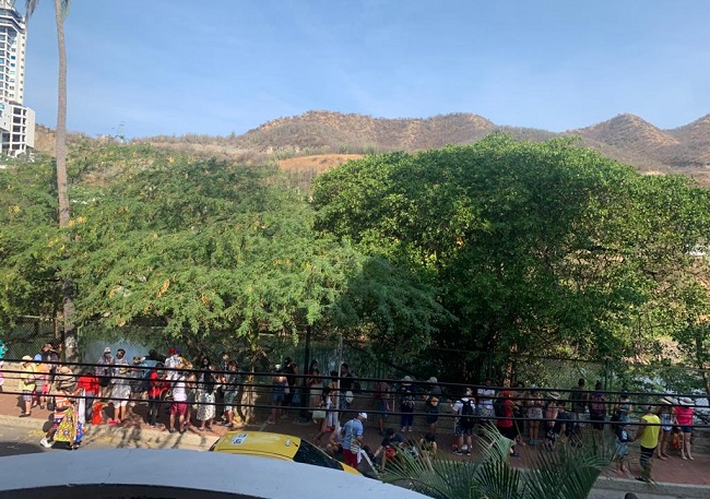 Varios visitantes se agrupan en el Callejón de Las Iguanas en El Rodadero este domingo, para entrar al balneario.