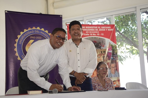 El Padre Mario González García, párroco del Centro de Bienestar al Anciano, realizando firma del acta de entrega de la donación al asilo, junto al doctor Pablo Vera Salazar, rector de la Univerdidad del Magdalena.