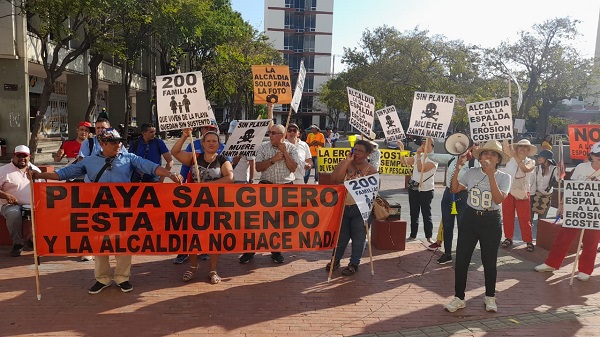 Comunidad protesta en las afueras de la Alcaldía, con pancartas, megáfonos y demás. 