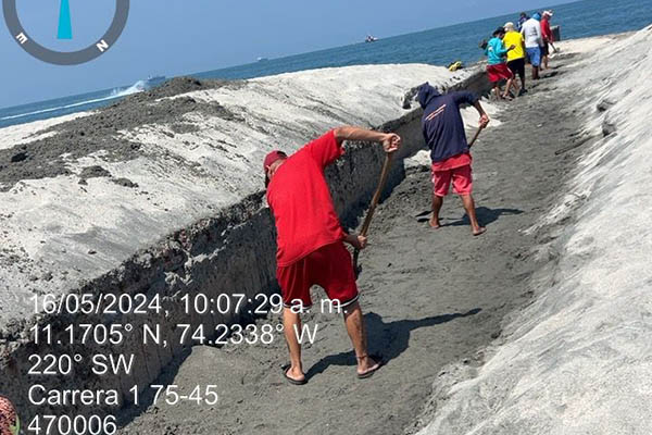 Habitantes del sector trabajan con palas para abrir el canal que comunica al lago para evitar una mayor tragedia natural.
