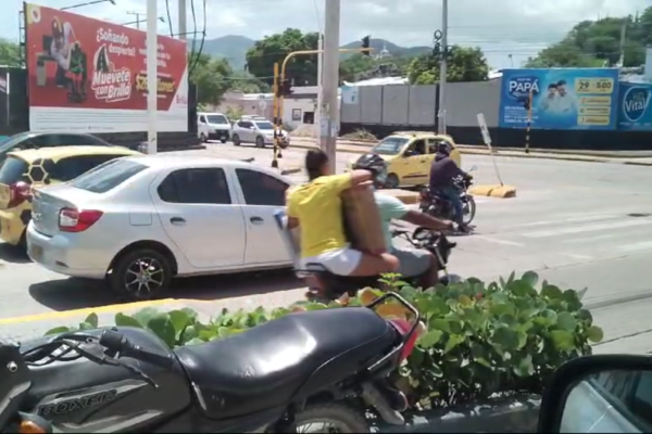 Moto que transportaba a una pasajera que llevaba consigo enorme caja.