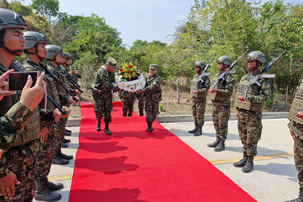 Miembros del Glorioso Ejército Nacional cargando corona de flores en homenaje a los soldados caídos.