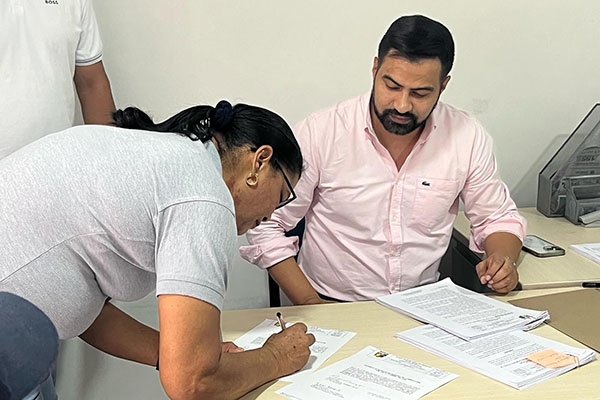 Alcalde Aníbal López realizando la entrega de títulos a los habitantes del municipio beneficiados en la jornada.