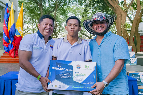 El Rector Pablo Vera Salazar, en compañía del alcalde de Chivolo, Andrés Escobar Mora, haciendo entrega de un computador a un estudiante beneficiario.