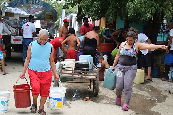Habitantes de un barrio de Santa Marta recolectado agua proveniente de un camión cisterna como referencia a la denuncia. Foto archivo EL INFORMADOR