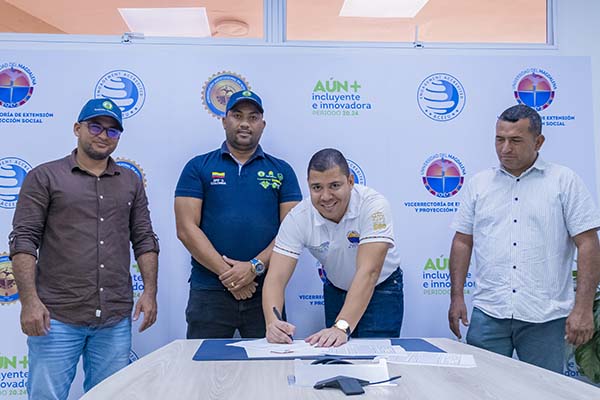 Fabio Andrés Fernández Pinto, director de Desarrollo Social de Unimagdalena, en compañía de Juan Luis Cuetto Tilano, coordinador del Centro de Formación para el Trabajo Coomulbanano firmando el convenio de formación educativa. Foto Unimagdalena 