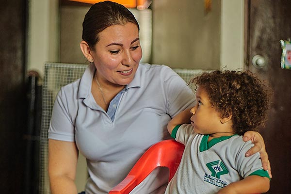 Una de las madres beneficiadas con el programa institucional de Unimagdalena, con uno de los niños de un hogar de paso del Icbf. Foto Unimagdalena 