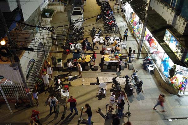 Vendedores ambulantes ocupan una calle peatonal y preparan alimentos junto a una rejilla de alcantarillado, sin control alguno por parte de Salud Distrital sobre las condiciones de manipulación y salubridad de los productos.
