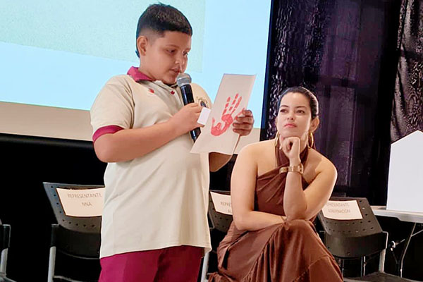 Niños y adolescentes de Santa Marta participaron en el acto simbólico del Día de las Manos Rojas, alzando sus manos como rechazo al reclutamiento forzado. Foto Jennifer Del Toro. 