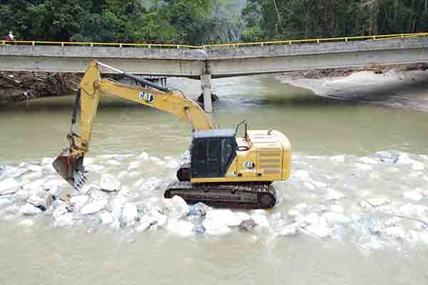 Maquinaria amarilla trabaja lentamente en el cauce del río Mendihuaca, mientras el puente aún no permite restablecer el tránsito entre el Magdalena y La Guajira lo que ha generado estancamientos económicos. Foto derechos reservados EL INFORMADOR 