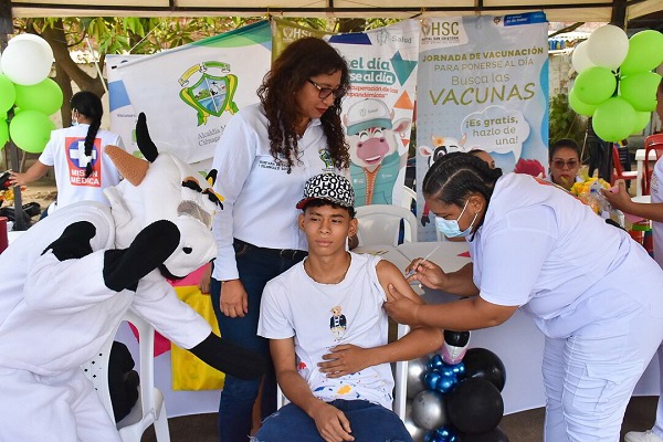 Funcionarias de la secretaría de salud de Ciénaga, colocando una vacuna a un joven beneficiado de la jornada. Foto Alcaldía de Ciénaga 