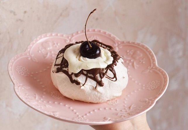 Pavlova con chocolate, crema y cereza.