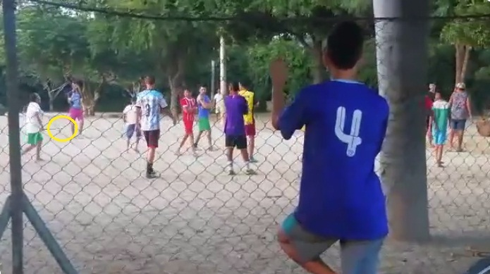 Una mujer golpea el piso con un machete para sacar a los deportistas de la cancha de fútbol