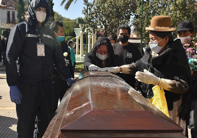 Familiares despiden el féretro con los restos de un fallecido a las puertas del cementerio general de la ciudad, que tiene problemas para realizar funerales ante el aumento de víctimas por COVID-19, este miércoles en Cochabamba (Bolivia). EFE