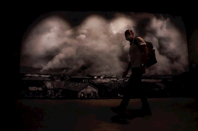 Un hombre pasa ante una foto que muestra los efectos de la bomba atónica sobre Hiroshima en el Museo Memorial de la Paz de la localidad japonesa este 5 de agosto.