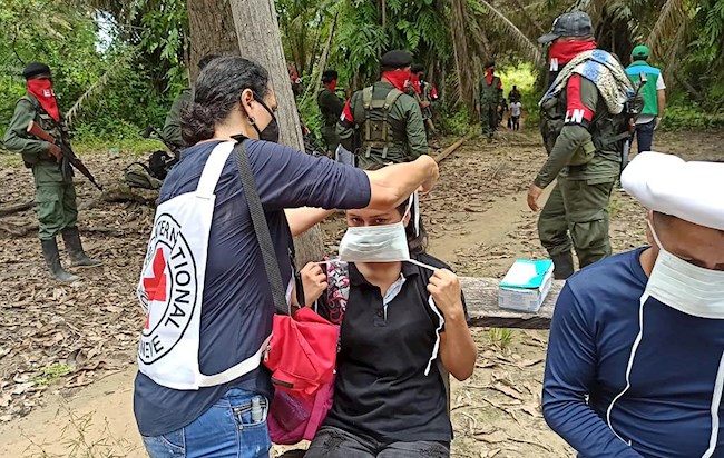 Foto que que muestra a un integrante del Eln mientras diligencia documentación con personal de la Cruz Roja Internacional este domingo en zona rural de la región del Catatumbo (Colombia).