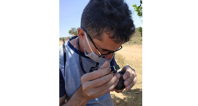Fotografía cedida hoy por el grupo de Astronomía Astro Agreste que muestra a uno de sus integrantes examinando un fragmento de meteorito recuperado en Santa Dilomena, Pernambuco (Brasil). EFE
