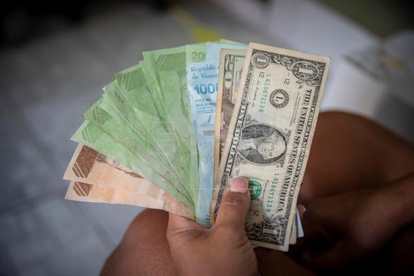 Fotografía de billetes de dólares y bolívares fuertes, en Caracas (Venezuela). EFE/Rayner Pena R/Archivo