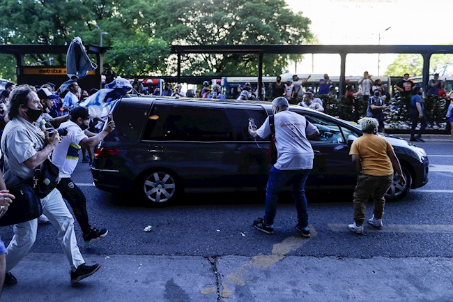 Hinchas rodean hoy el cortejo fúnebre de Diego Armando Maradona durante su salida hacia el cementerio Jardín Bella Vista, en Buenos Aires (Argentina). EFE