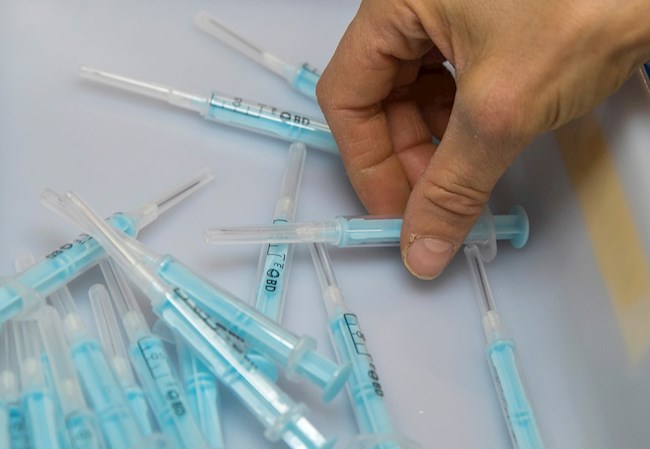 Una operaria de la planta de la empresa Becton Dickinson de Fraga (Huesca), inspecciona unas muestras de la jeringuilla que fabrican para administrar la vacuna contra el coronavirus. EFE