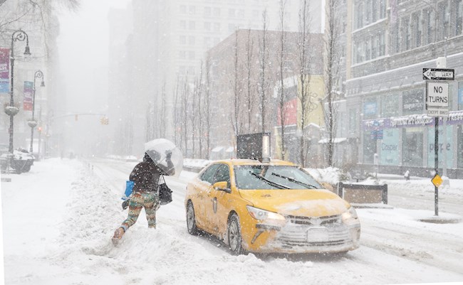  Una mujer corre hacia un taxi en Union Square, en Nueva York, EEUU, durante la nevada de hoy 1 de Febrero de 2021. EFE