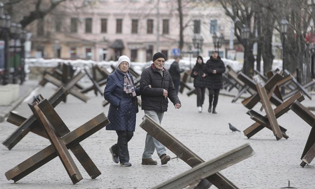 Ciudadanos locales caminan en una calle entre erizos checos antitanque en la ciudad de Odesa, en el sur de Ucrania invadida por Rusia desde el pasado 24 de febrero.