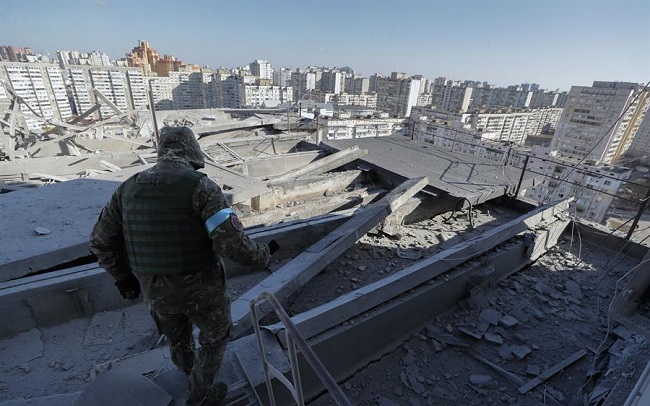 Un militar ucraniano investiga el piso dañado del edificio residencial que fue bombardeado anoche en Kiev, Ucrania.