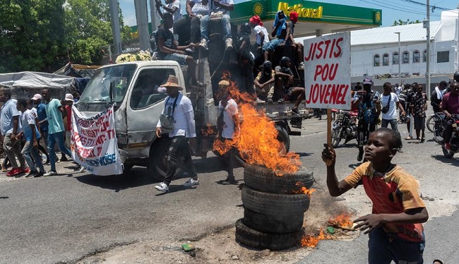 Varias personas protestan para pedir justicia por el asesinato del presidente Jovenel Moïse durante el aniversario de su magnicidio.