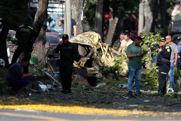 Integrantes de la Policía inspeccionan la zona del atentado tras una explosión en inmediaciones de la Escuela Militar de Aviación Marco Fidel Suárez este jueves, en Cali (Colombia). Al menos cinco personas murieron y 36 resultaron heridas por un atentado perpetrado con un camión bomba. EFE/ Ernesto Guzmán Jr