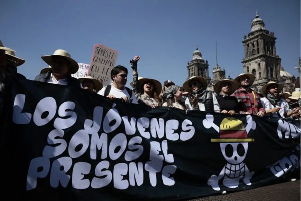 Personas sostienen un cartel durante una protesta este sábado, en inmediaciones del Palacio Nacional en Ciudad de México (México). EFE/ José Méndez