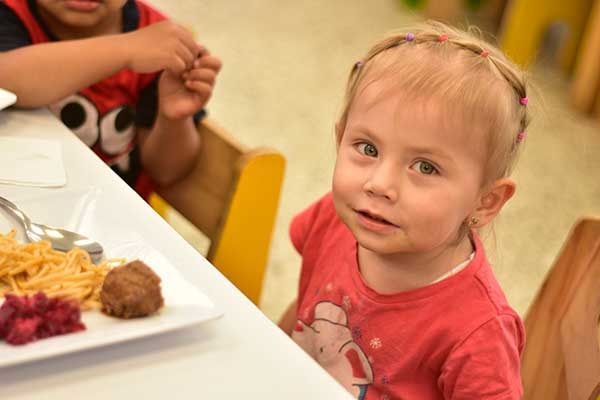 Imagen que muestra a una niña recibiendo su alimentación.  Foto ICBF