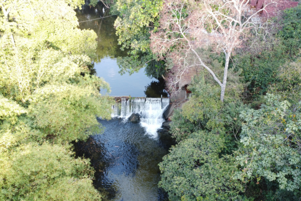 Vista aérea del Río Toribio, rodeado de abundante vegetación y con el cauce del río destacándose en el centro del paisaje.