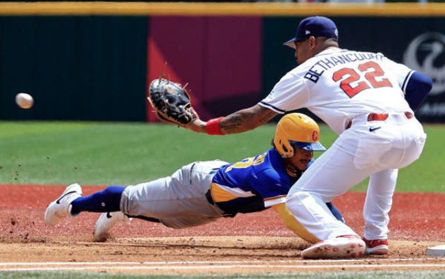  Gustavo Campero (i) de Colombia se lanza a primera base ante Christian Bethancourt de Panamá este lunes, en un partido del Clásico Mundial de Béisbol entre Panamá y Colombia en el estadio Hiram Bithorn en San Juan (Puerto Rico). EFE/ Thais Llorca