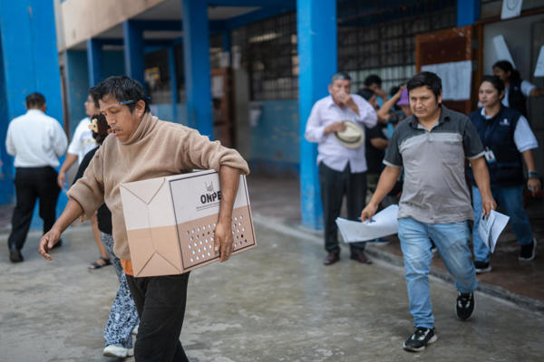 Una persona trasladan una urna electoral este lunes, en el colegio San Luis Gonzaga, en el distrito de San Juan de Miraflores en Lima (Perú). Los más de 52.000 peruanos que se quedaron el domingo sin votar en las elecciones generales al no abrir sus colegios por el retraso en la llegada del material electoral madrugaron este lunes para sufragar, en una inédita jornada adicional. EFE/ John Reyes Mejia