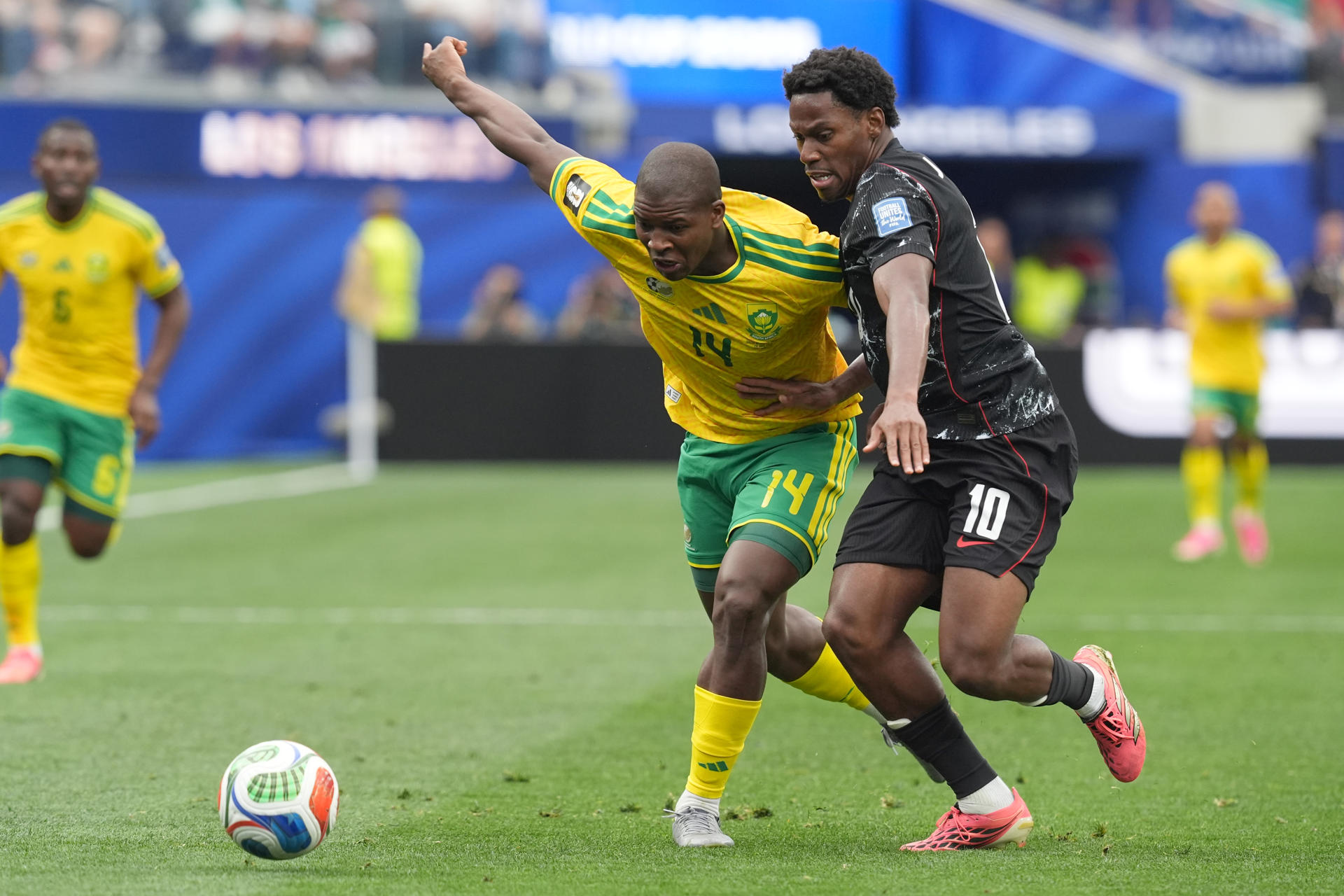 Mbekezeli Mbokazi (i) de Sudáfrica disputa un balón con Jonathan David de Canadá este domingo, en un partido por los dieciseisavos de final del Mundial de la FIFA 2026 entre Sudáfrica y Canadá en el estadio SoFi en Los Ángeles (Estados Unidos). EFE/ Omar Alonso