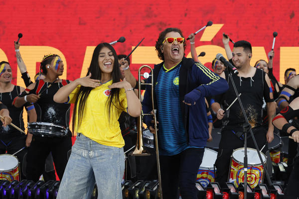 Los artistas colombianos Carlos Vives (c) y María Fuell (c-i) cantan este lunes, antes de un partido amistoso entre Colombia y Costa Rica previo a la Copa Mundial de Fútbol de 2026, en el estadio El Campín en Bogotá (Colombia). EFE