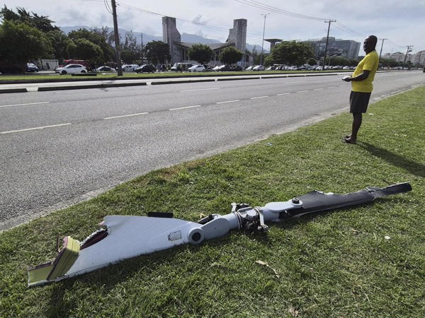 Fotografía cedida este domingo por Roberta Durço que muestra a una persona observando un fragmento de uno de los helicópteros que colisionaron en el barrio Recreio dos Bandeirantes, en Río de Janeiro (Brasil). La colisión de dos helicópteros esta mañana deja un saldo de al menos seis personas fallecidas, según informaron fuentes oficiales. EFE/ Roberta Durço 