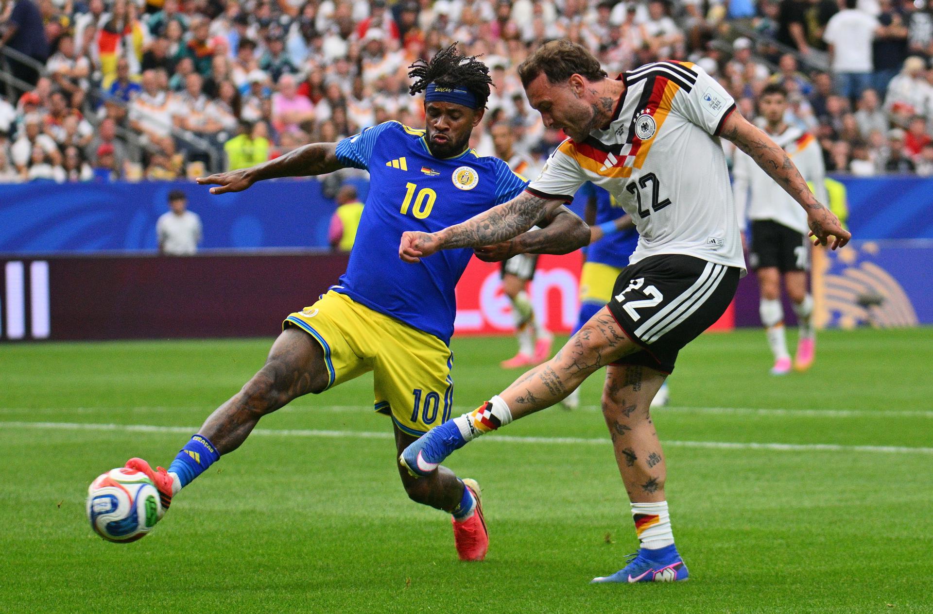 Leandro Bacuna de Curazao (izq.) y David Raum de Alemania en acción durante el partido de la fase de grupos de la Copa Mundial de la FIFA 2026 entre Alemania y Curazao, en Houston, EE. UU., el 14 de junio de 2026. (Alemania) EFE/EPA/SAM WASSON