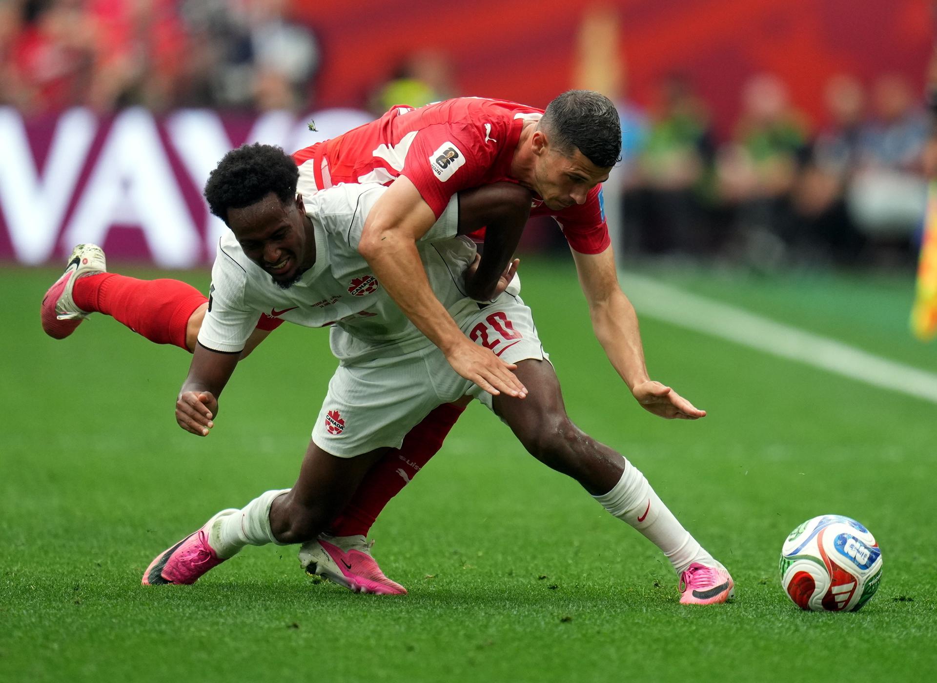 Ali Ahmed de Canadá (al frente) y Remo Freuler de Suiza en acción durante el partido de la fase de grupos de la Copa Mundial de la FIFA 2026 entre Suiza y Canadá, en Vancouver, Canadá, el 24 de junio de 2026. (Suiza) EFE/EPA/BOB FRID
