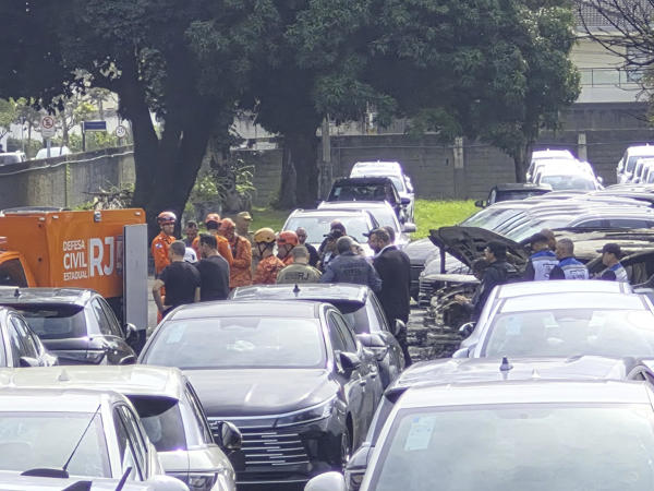 otografía cedida este domingo por Roberta Durço que muestra a integrantes de equipos de rescate recorriendo la zona donde cayó uno de los helicópteros que colisionaron en el barrio Recreio dos Bandeirantes, en Río de Janeiro (Brasil). Una de las aeronaves se incendió tras caer dentro de un estacionamiento privado y el fuego destruyó a unos veinte automóviles eléctricos que se encontraban estacionados en el lugar. EFE/ Roberta Durço