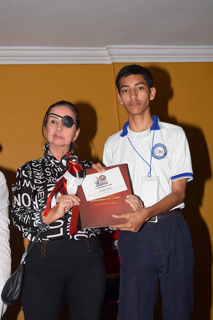 Ronaldo Carvajal Ramos, de la IED San Francisco Javier, se ganó una beca completa de la Corporación Bolivariana del Norte. Lo acompaña María Teresa Escobar.