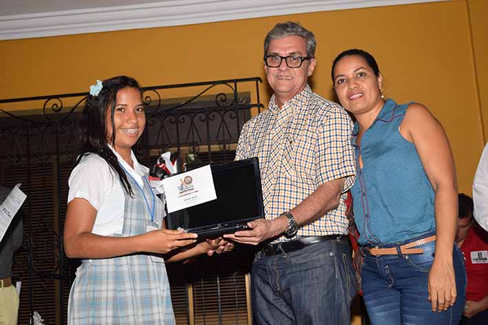 Carolina Fernández de la IED Norma Superior María Auxiliadora, recibió un computador donado por SAO, acompañada de Alfonso Delgado Campo y su madre.