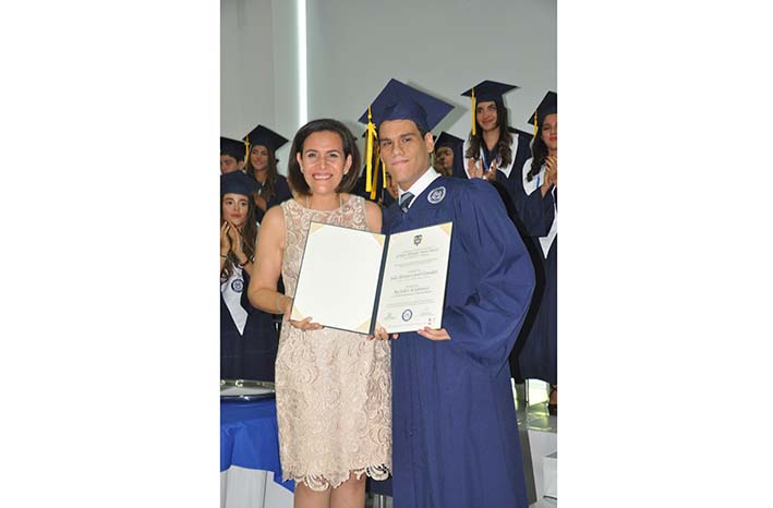 Julio Alfonso Curiel González, recibe su diploma como Bachiller Académico con Profundización en Humanidades, de manos de la rectora, Adriana Maldonado.