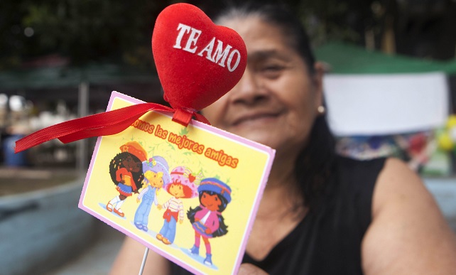 Una mujer espera en la Plaza Central de Tegucigalpa, Honduras, para entregar un obsequio para celebrar el Día de los enamorados o de San Valentín.